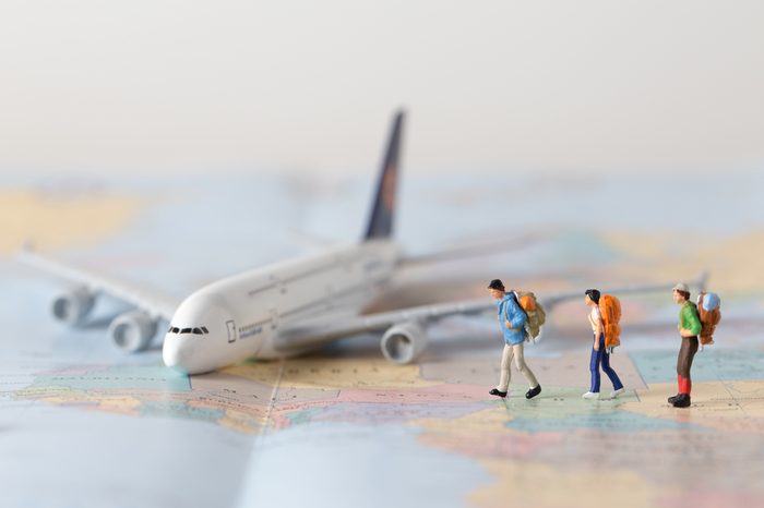 Miniature model team traveller model standing together on map, people travel in concept,