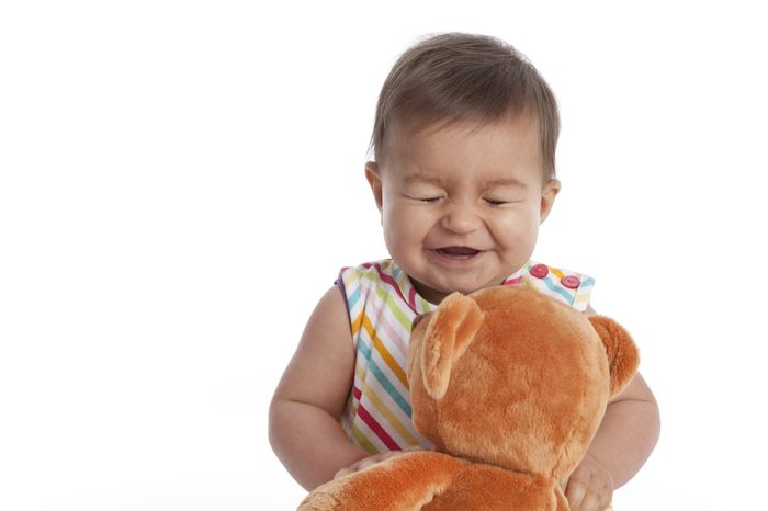 Baby girl having fun with her toy bear