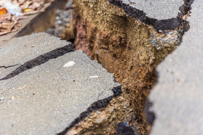 Asphalt road cracked and broken from earthquake, Louangphabang, Laos. Close-up