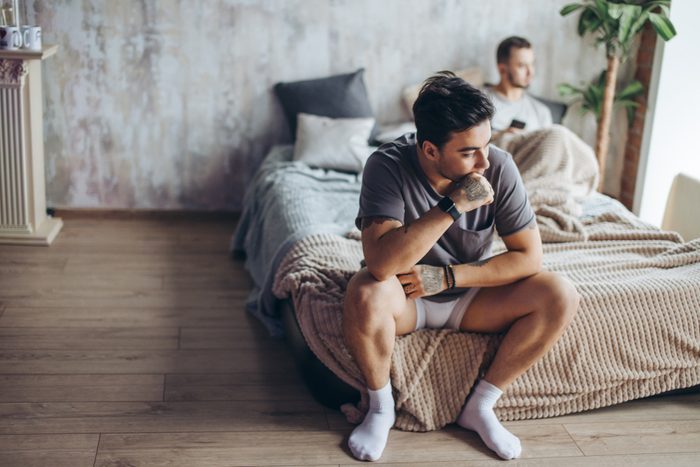 Young gay couple in quarrel at home. LGBT and same- sex relationship concept