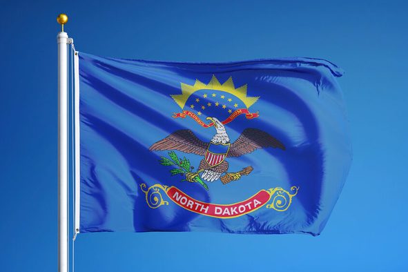 North Dakota (U.S. state) flag waving against clear blue sky, close up, isolated with clipping path mask alpha channel transparency, perfect for film, news, composition