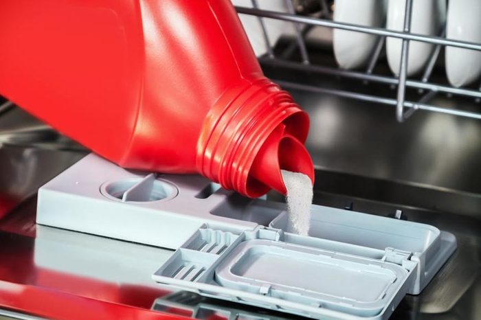 pouring the powder into the dishwasher. work on cleaning the house