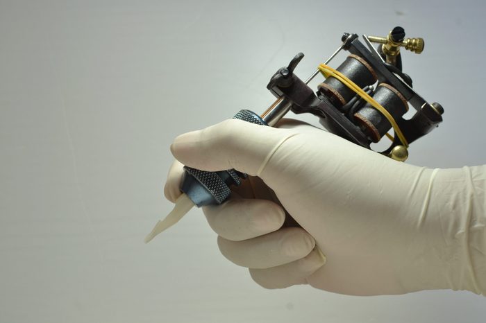 holding the tattoo gun