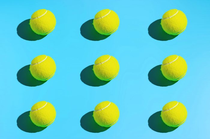 Symmetrical tennis balls on a blue background. Sports background.