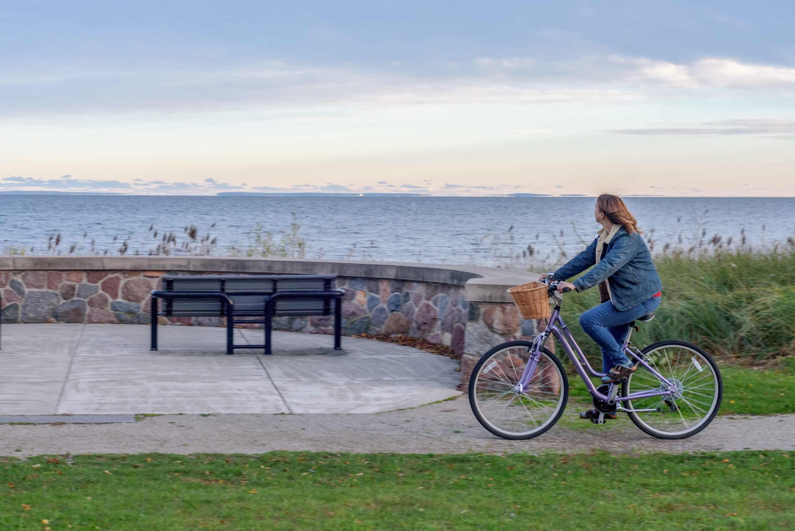 Woman Riding Bicycle At Beach Against Sky During Sunset