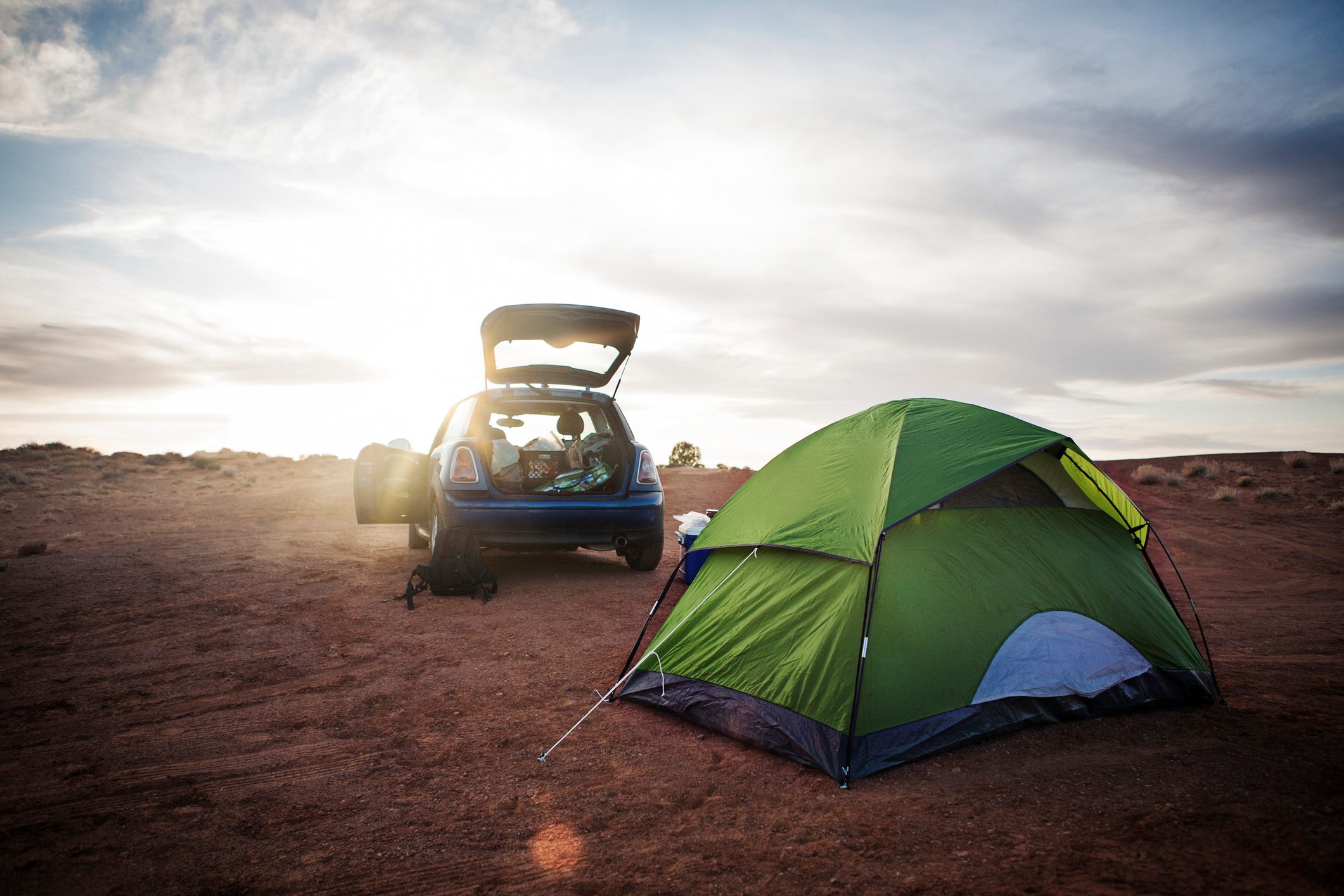 Tent and car on field against cloudy sky