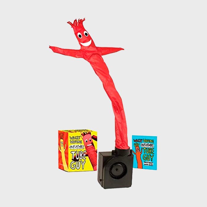 Red inflatable tube guy flails energetically, supported by a black base. Nearby, colorful packaging reads 