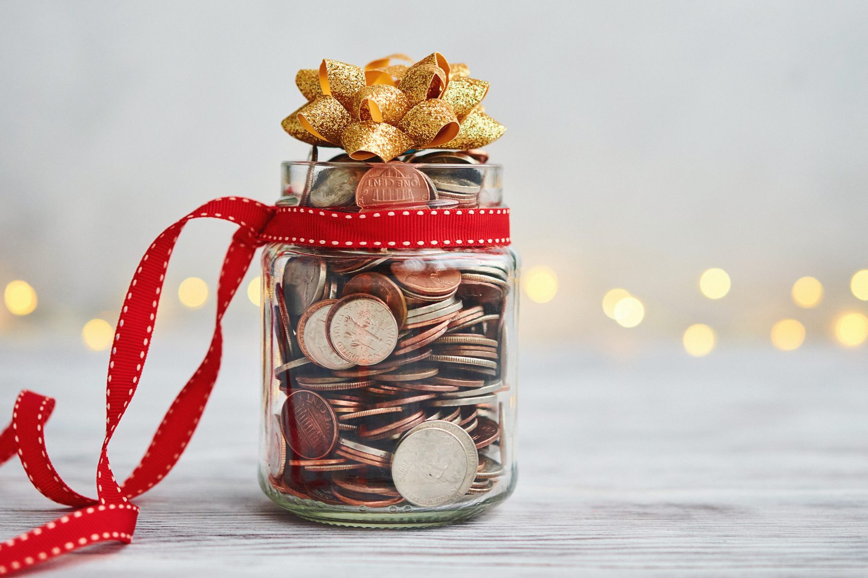 Holiday Savings Jar Filled with Coins and Christmas Ribbon and Bow