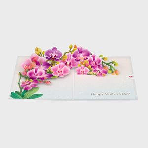 Card displaying pink and purple orchids arranged artistically, surrounded by a soft background. Text reads, 