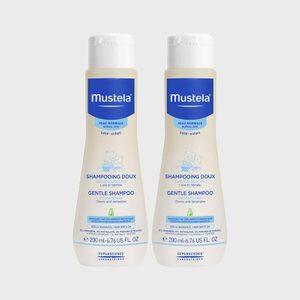 Two bottles of Mustela gentle shampoo stand side by side against a plain background, labeled for delicate hair care.