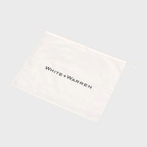 A white drawstring bag lies flat displaying 
