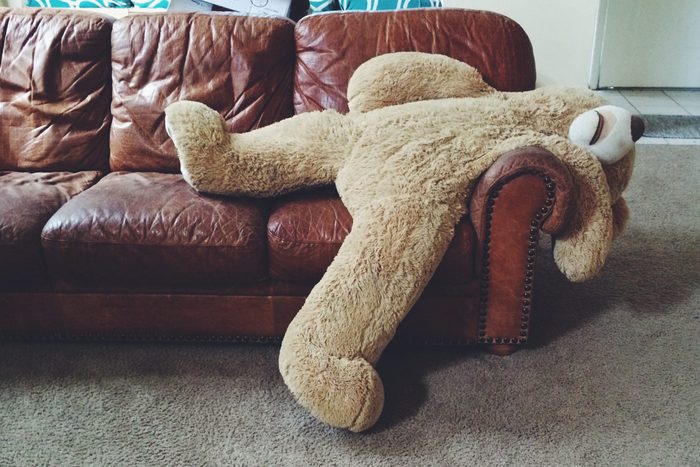 Stuffed teddy bear laying on couch