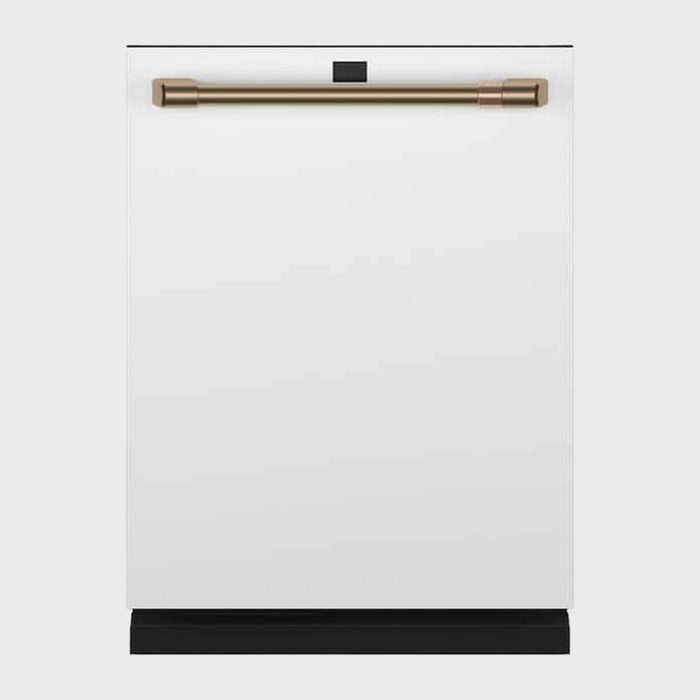 White dishwasher with a brass handle stands against a plain grey background.