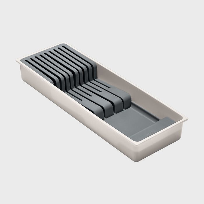 Tray with slotted dividers, positioned horizontally, designed for organized storage, placed on a plain, light-gray background.