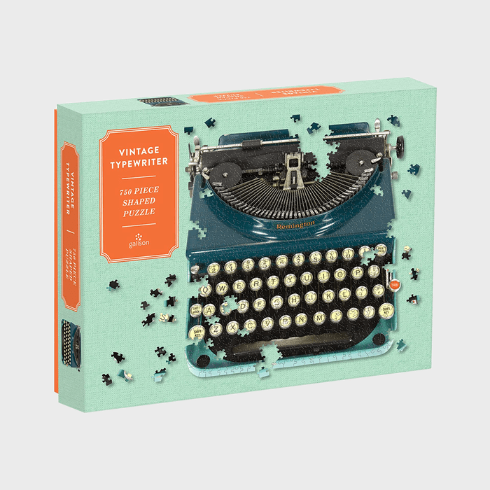 Typewriter puzzle box, displaying scattered black pieces, features labeled 