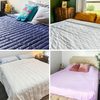 Beds with colorful quilts are neatly made; each room features unique pillows and bedside tables, creating cozy and varied bedroom environments.
