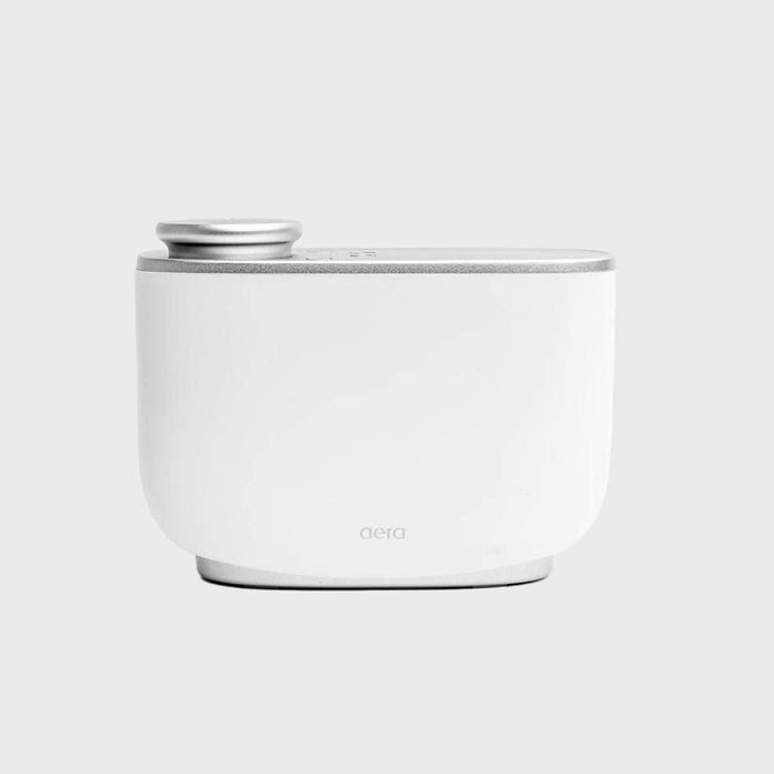 White scent diffuser resting on a surface, designed for home use, marked 