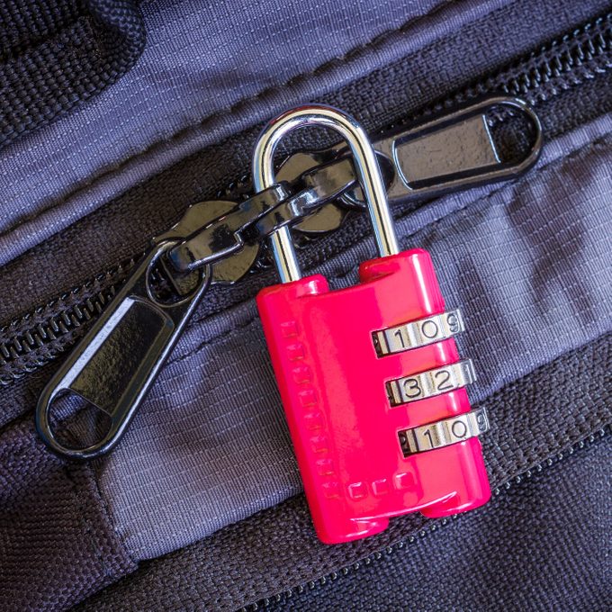 Pink combination padlock on navy and black suitcase